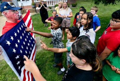  students pointing to flag