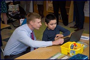 Director of Technology Aaron McBride works with a student 